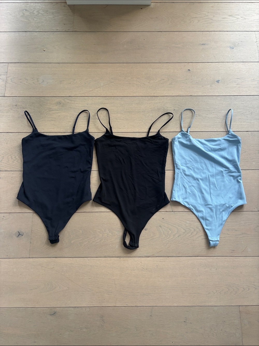 Set of three contour bodysuits in size small.